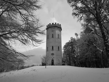 Built structure on snow covered land against sky