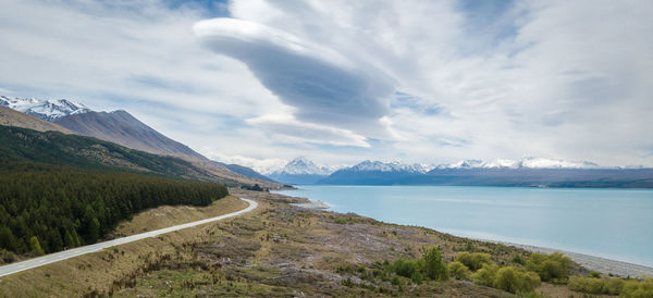 Scenic view of road by sea against sky