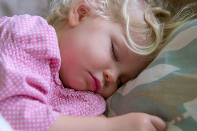 Close-up of girl sleeping on bed at home