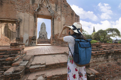 Rear view of woman standing outside temple