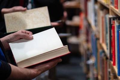 Midsection of people holding books in library