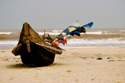 Traditional windmill on beach against sky