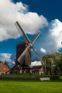 Traditional windmill on field against sky