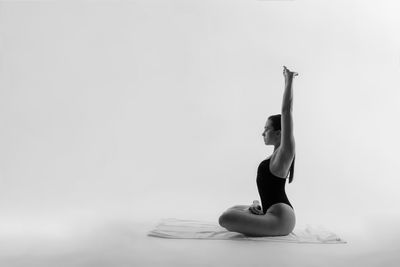 Low angle view of woman with arms raised against sky