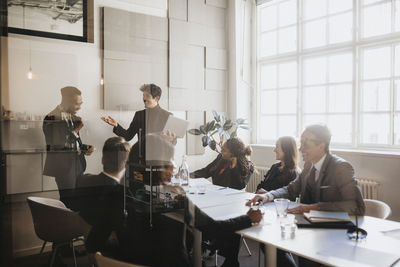 Male and female entrepreneurs discussing during business meeting in board room at office