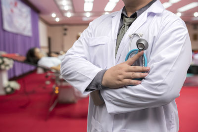 Midsection of doctor holding stethoscope