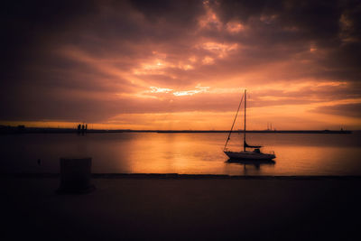 Silhouette sailboat on sea against sky during sunset