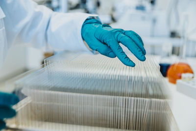 Scientist choosing microscope slide while standing at laboratory