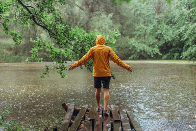 Rear view of boy standing on water