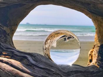Scenic view of beach against sky and glass orb