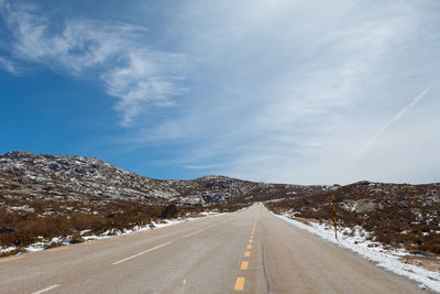 Empty road along countryside landscape