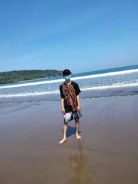 Rear view of person on beach against sky