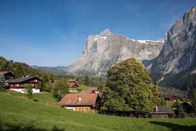 Scenic view of houses and mountains against sky