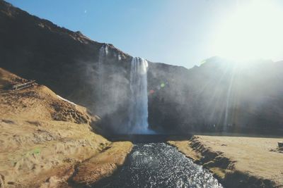 Scenic view of waterfall against sky