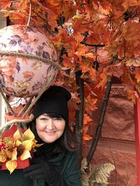 Portrait of smiling young woman standing during autumn