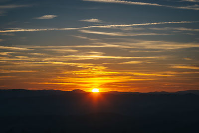 Scenic view of silhouette mountains against sky during sunset