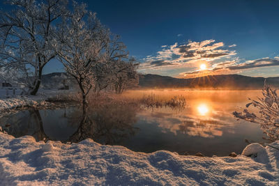 Scenic view of lake against sky during winter