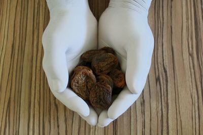 Hands in gloves with dried apricots 