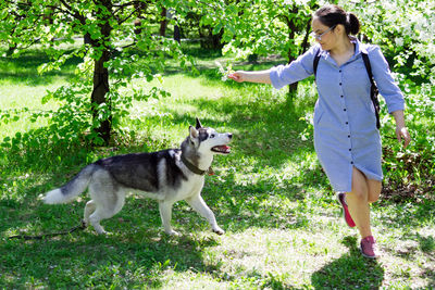 Woman with dog standing by plants