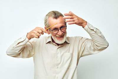 Portrait of young man standing against white background