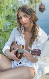 Portrait of young woman holding guitar