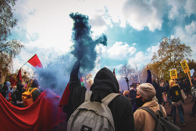 Rear view of people walking against sky