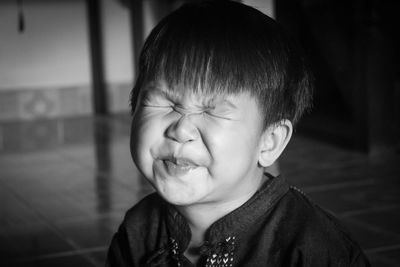 Close-up of cute boy making face at home