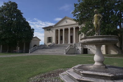 Statue in park against building