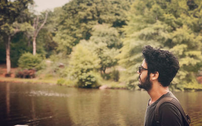 Side view of man looking away in lake