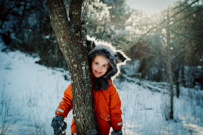 Portrait of girl standing on snow covered land