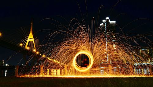Wire wool spinning by chao phraya river with rama viii bridge in background
