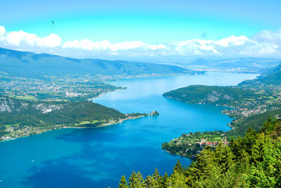 High angle view of sea and mountains against blue sky