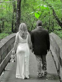 Rear view of woman walking on footpath in forest