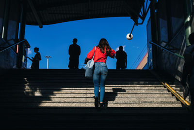 Rear view of people walking on staircase