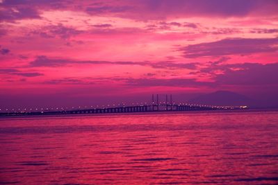 View of bridge over sea against sunset sky