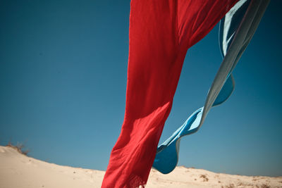 Flag waving in desert against clear blue sky