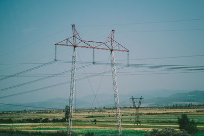 Low angle view of electricity pylon on land against sky
