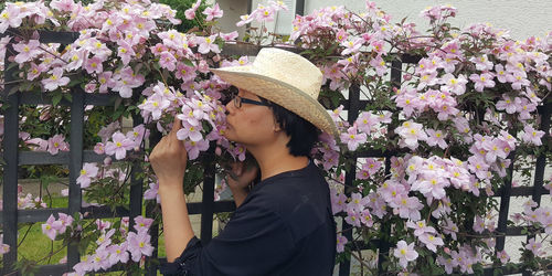 Woman smelling pink flowering plants