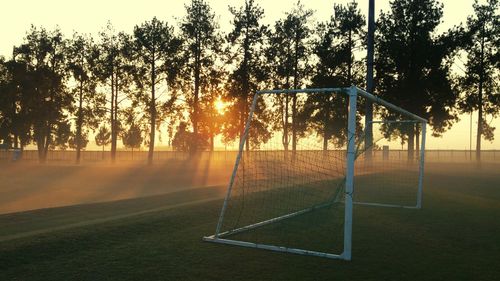 Goal post on soccer field during sunrise