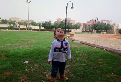 Boy standing on grass at park