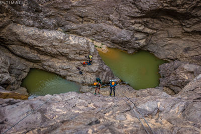 People on rock by river