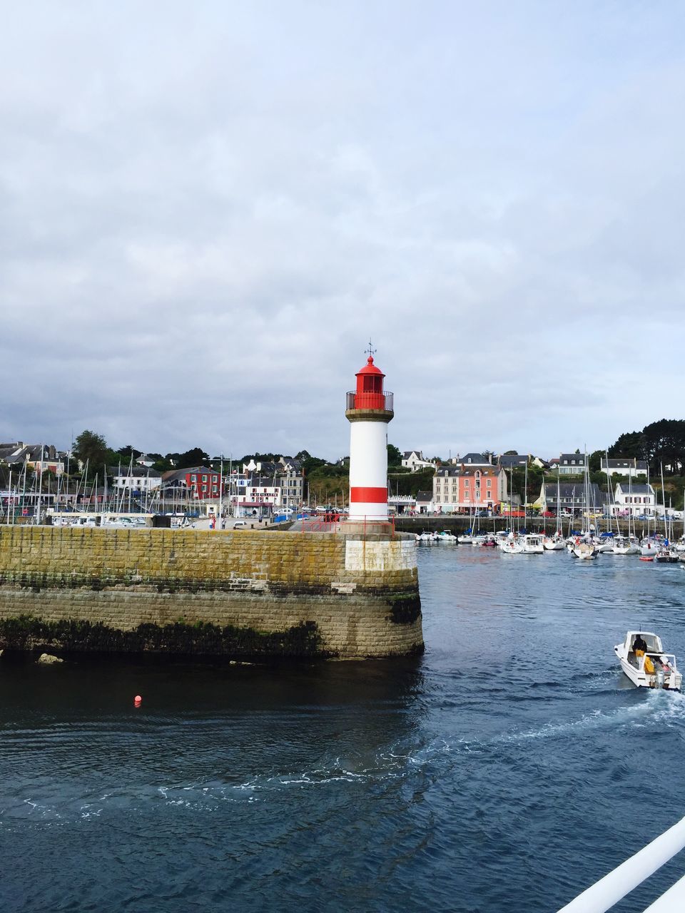 building exterior, architecture, water, built structure, lighthouse, guidance, sky, waterfront, red, sea, safety, river, protection, cloud - sky, direction, security, tower, city, day, rippled