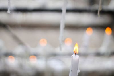 Close-up of illuminated candles against blurred background