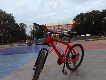 Bicycle on street in city against sky