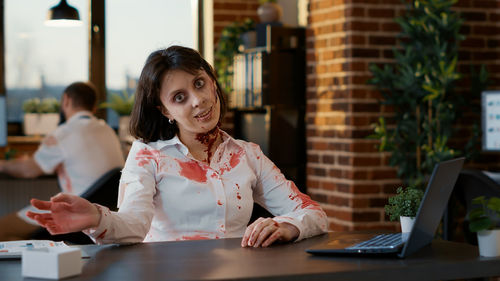 Smiling woman using laptop at office