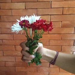 Close-up of hand holding flowers