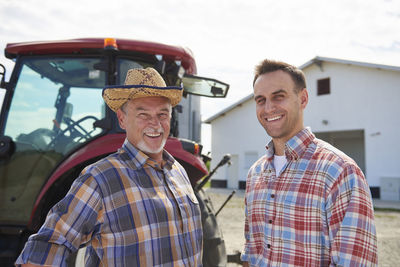 Portrait of two farmers in front of the barn