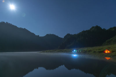 Scenic view of lake against sky at night