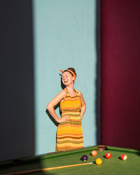 Woman laughing while standing by pool table