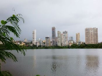 River by buildings against sky